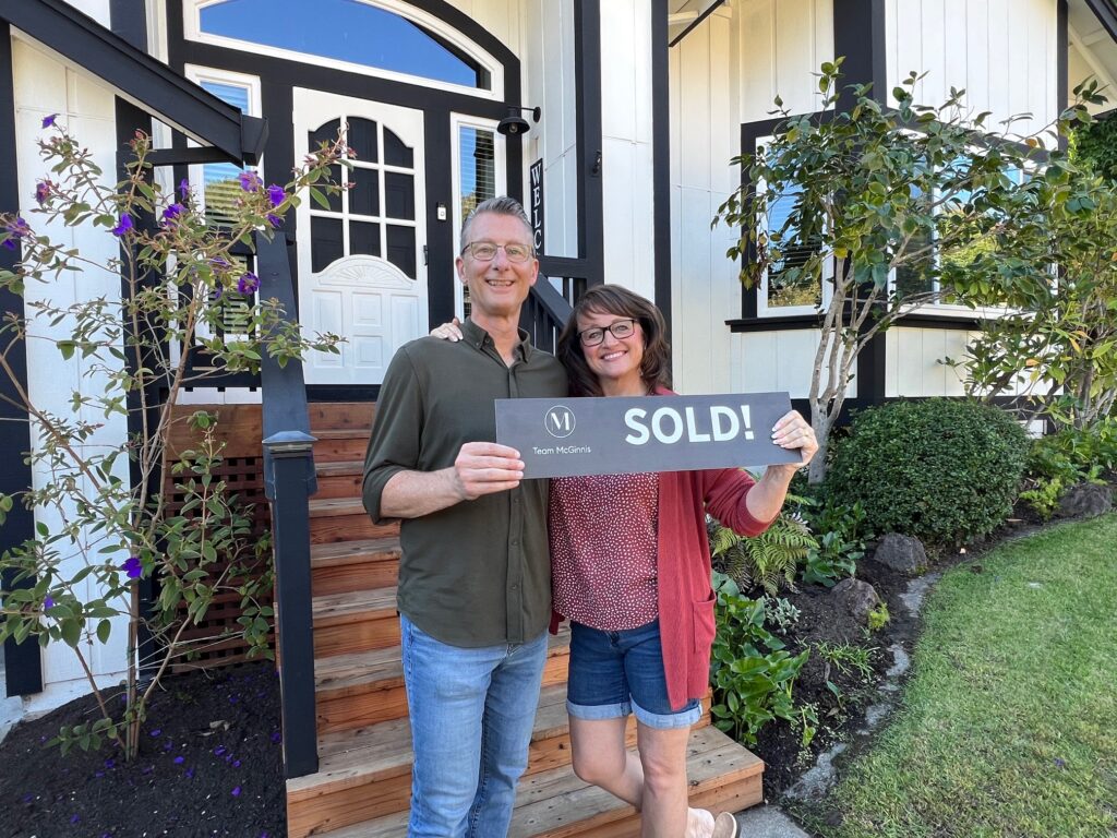 Novato home sellers holding a sold sign